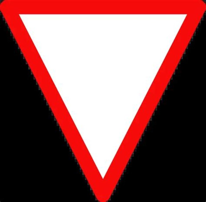 a red and white triangular sign at an intersection means