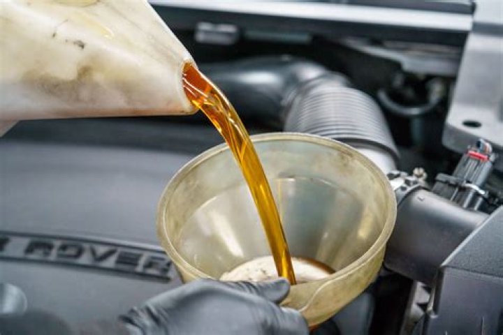 putting oil in car